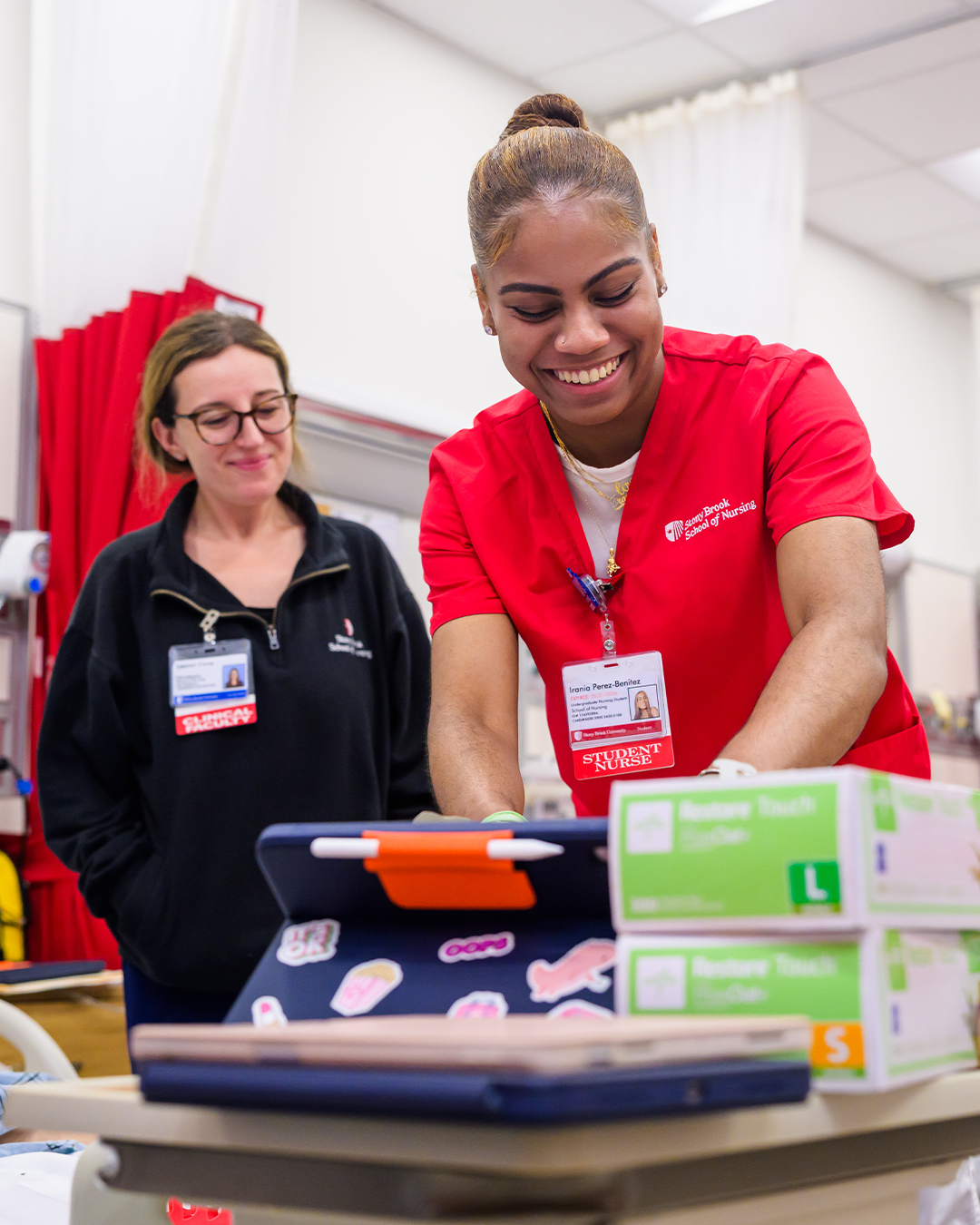 A nursing student and a faculty member working in the NEXUS Simulation Center. 